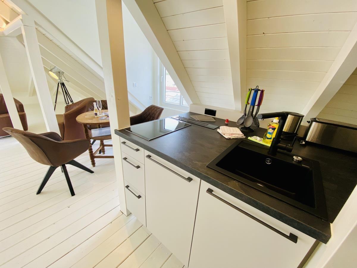 Schlafzimmer mit Doppelbett, Dachfenster und zwei Nachttischen mit Wandlampen.