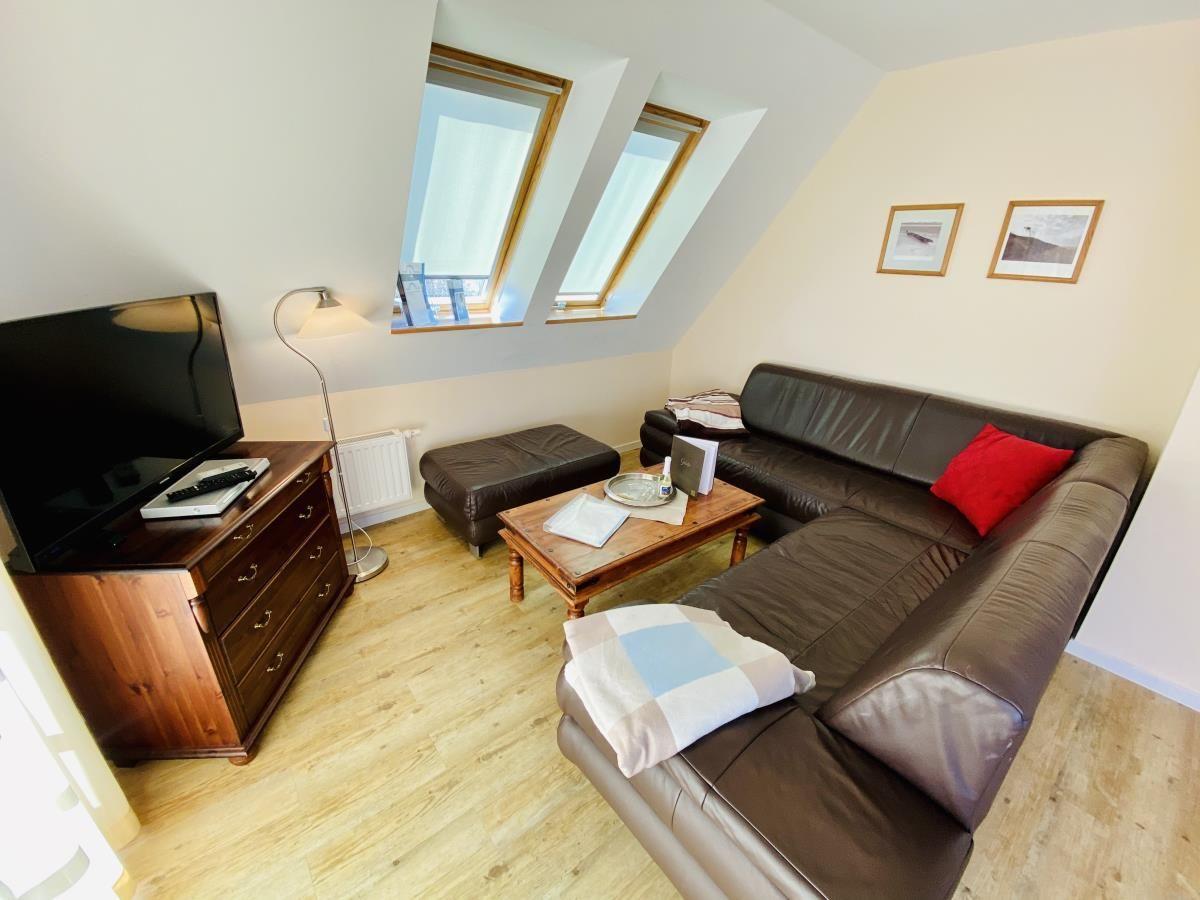 Schlafzimmer mit Dachfenster, Bett, Nachttischen und Stuhl.