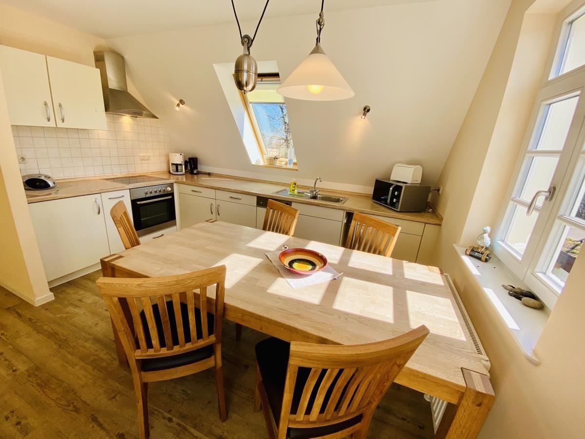Schlafzimmer mit Holzbett, Kleiderschrank und Dachfenster.