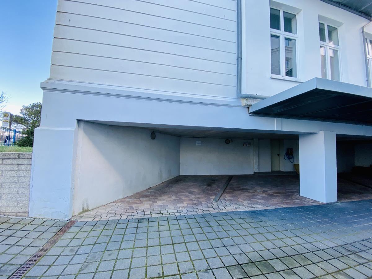 Ferienhaus mit Leuchtturm im Hintergrund und Fotos von Vermietern.