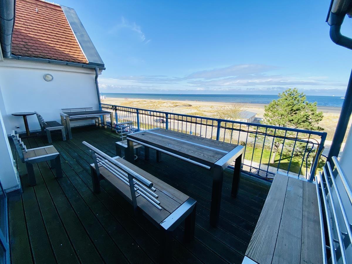 Wohnzimmer mit Sofa, Couchtisch und Fernseher. Holzboden und Dachfenster.