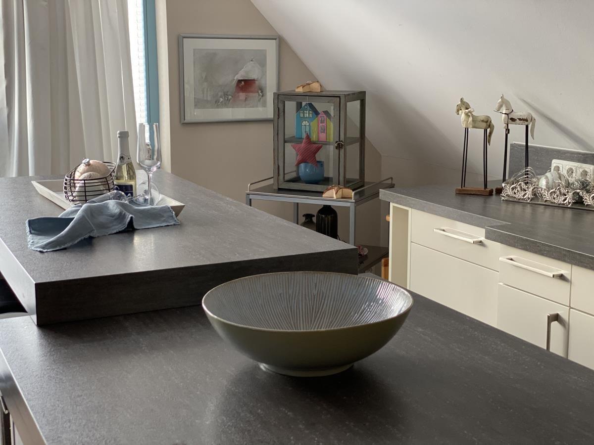 Wohnbereich mit Sofa, Wandbild und Holzdekoration.