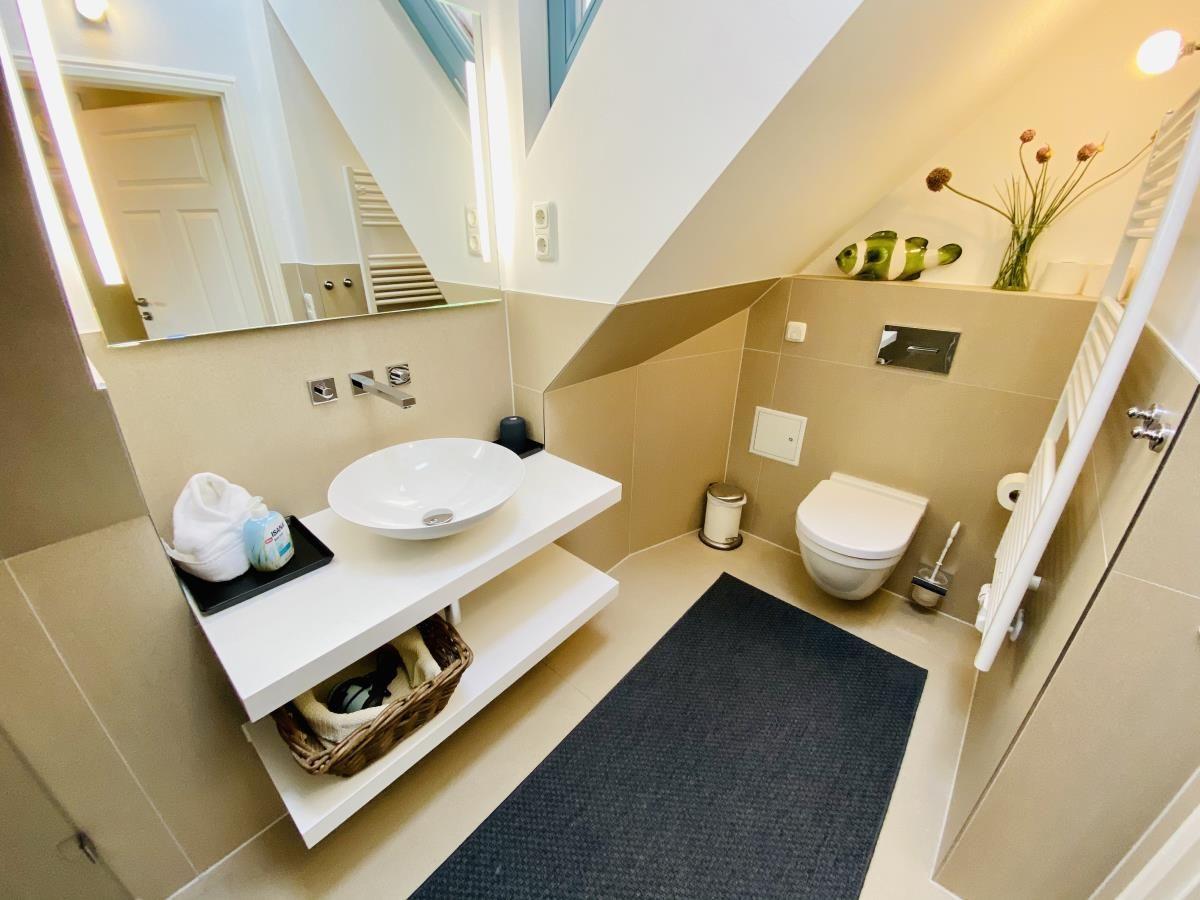 Schlafzimmer mit Holzbett und Fenster. Flur mit Wandbildern und Tür.