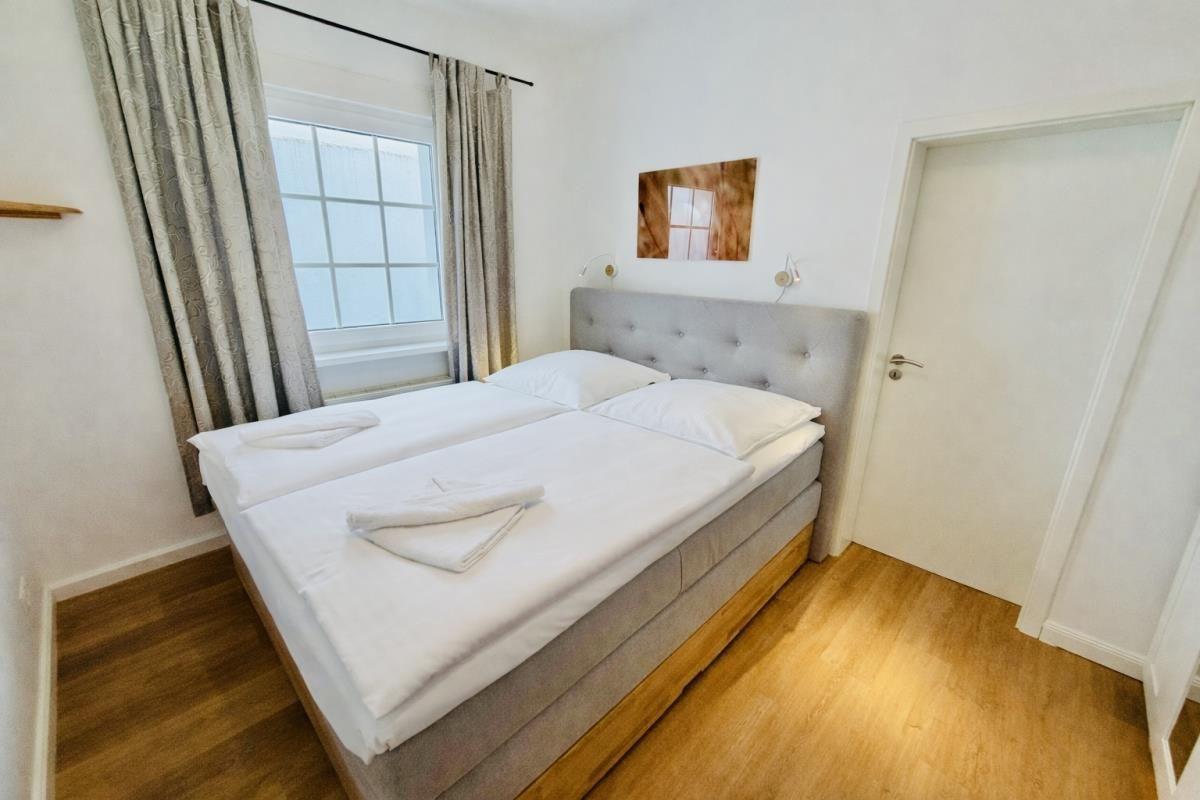 Flur mit Spiegel, Garderobe und Blick auf Balkon.