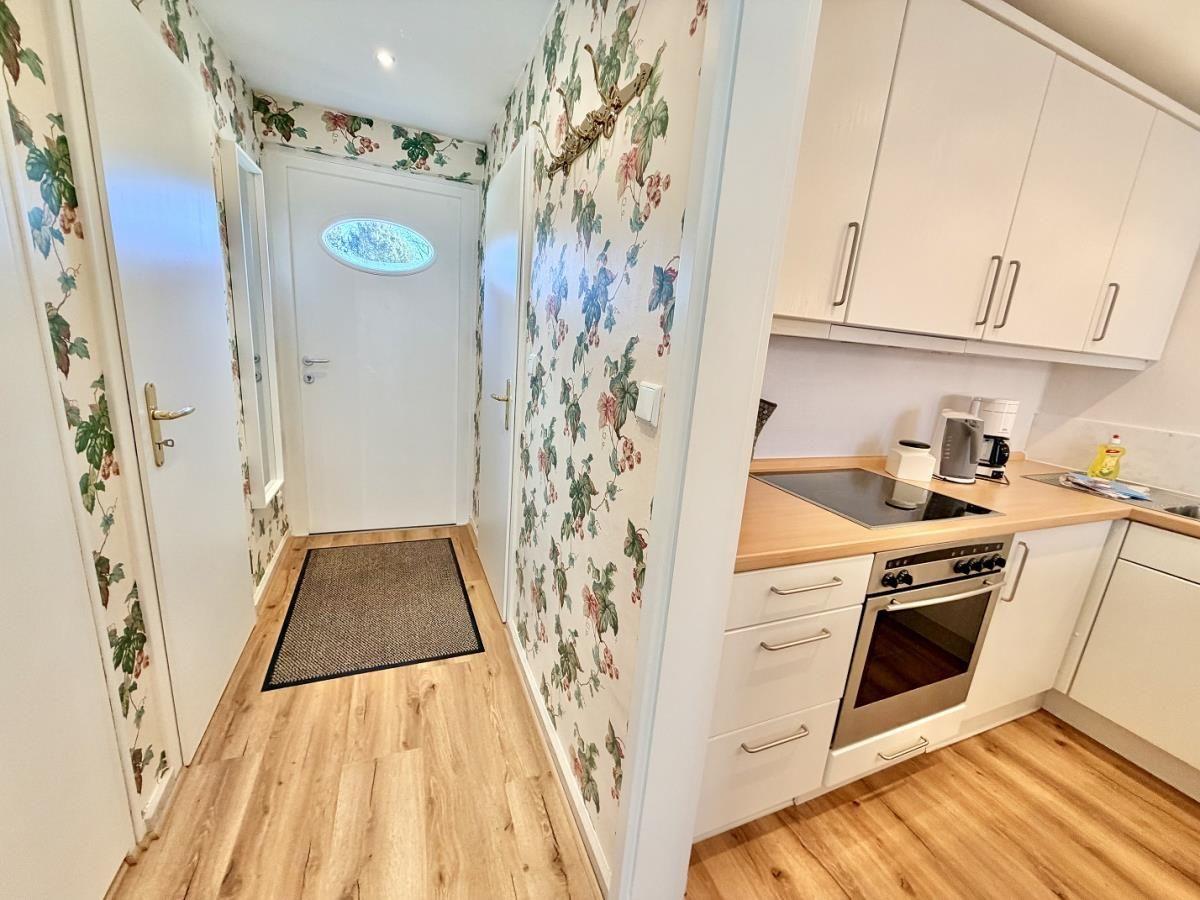 Badezimmer mit Dusche, Toilette und Waschbecken auf Holzfußboden.