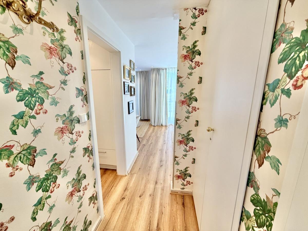 Runder Tisch mit Blumenvase, Gläsern und Stuhl im Freien.
