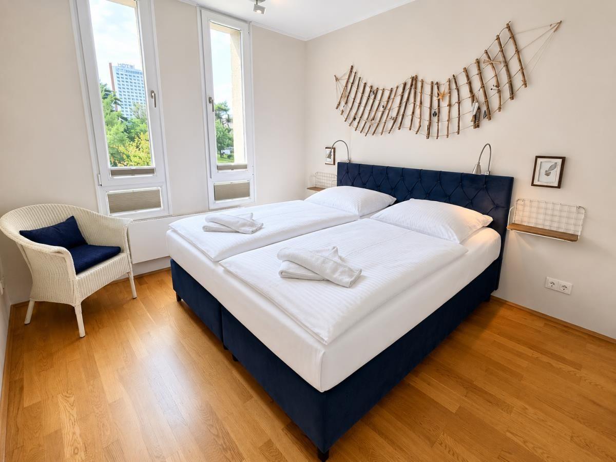 Badezimmer mit Toilette, Bidet, Handtuchständer und Wanddekoration.