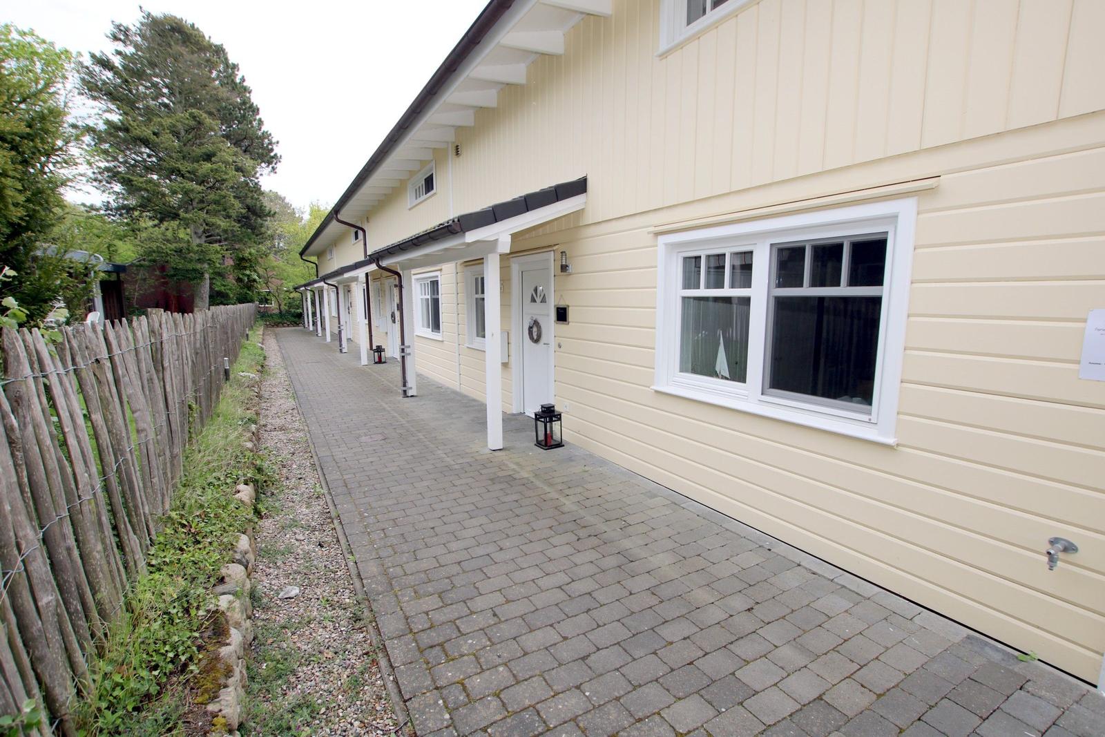 Hinterhof mit Spielplatz, Rutsche und Trampolin. Rotes Haus mit Balkon.