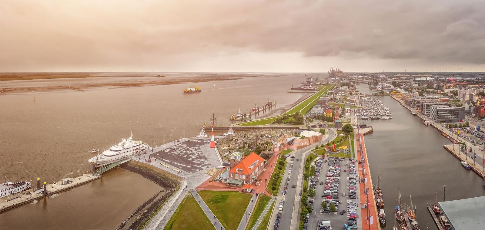Hafen mit Booten und modernem Gebäude im Hintergrund.