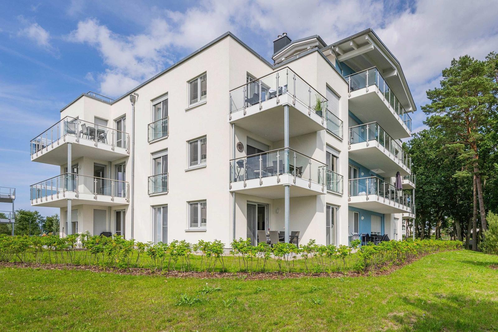 Wohnbereich mit Spielzimmer, roten Sesseln und Holzboden. Spielzeug und Wanddekoration sichtbar.