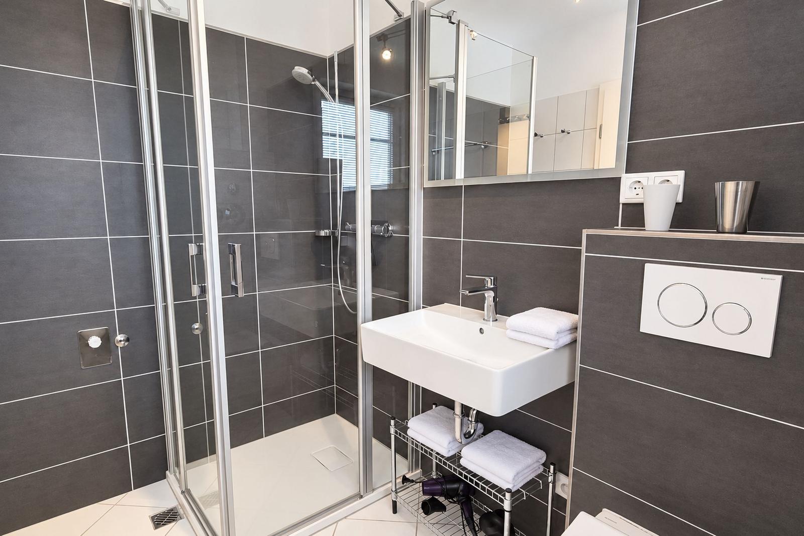 Wohnung mit Küche, Schlafzimmer, Bad und Terrasse. Mit Kompass für Orientierung.