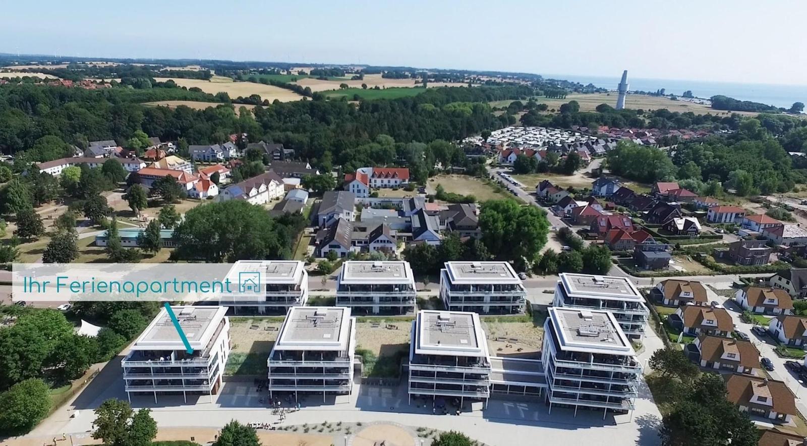 Holiday apartment in modern building complex with view of coastal landscape and harbor.