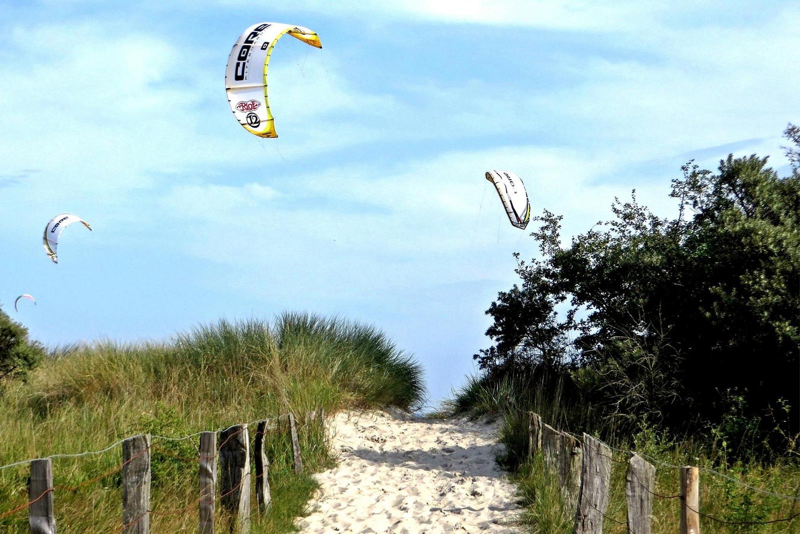 Strand mit bunten Liegestühlen und klarem Wasser unter blauem Himmel.