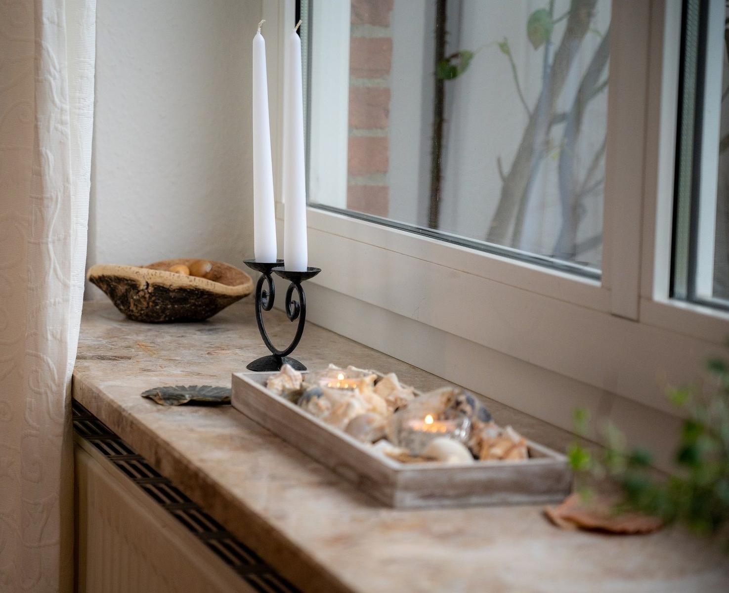 Bad mit Waschbecken, Spiegelschrank und Pflanze.