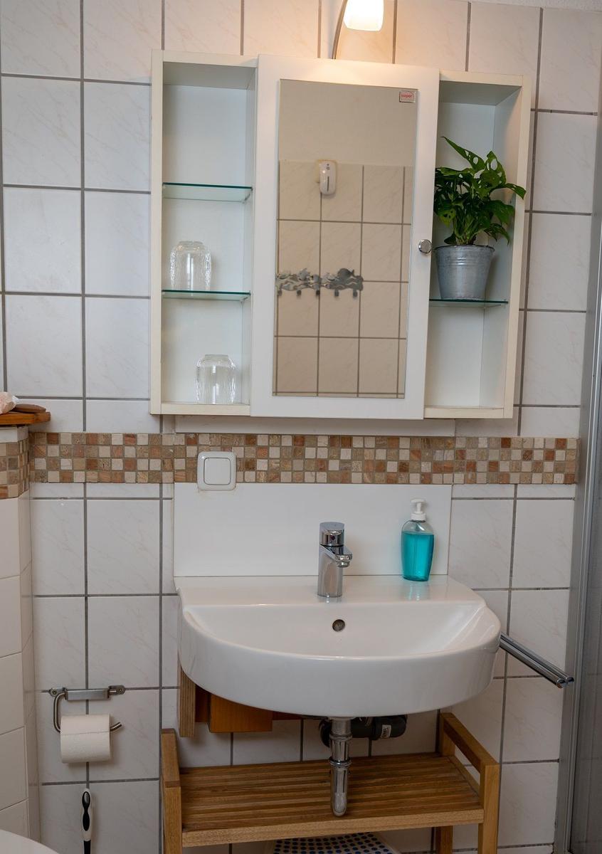 Küche mit Holzschränken, Spüle, Kühlschrank und Waschmaschine
