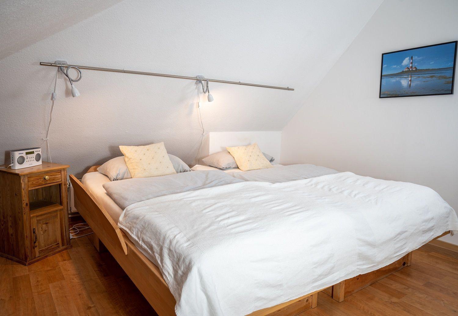 Schlafzimmer mit Dachschräge, Dachfenster, Bett, Kleiderschrank und Nachttisch.