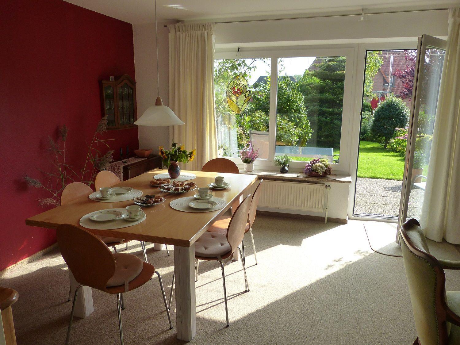 Wohnzimmer mit zwei Sesseln, Fernseher und Blick auf den Garten.