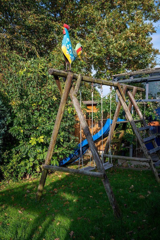 Gartenmöbel mit Tisch, Obst und Blumen vor einem Haus