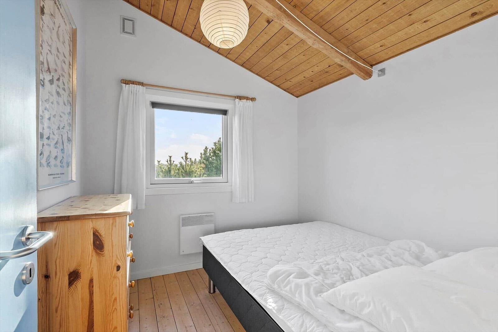 Unser Ferienhaus liegt an einer gravelweg durch grasland mit sandhügeln im Hintergrund.