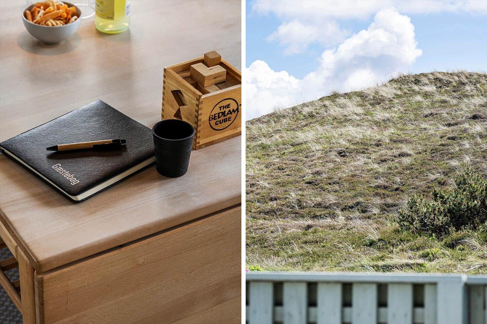 Holztisch mit Flasche und Gläsern im Gras auf einer Düne.