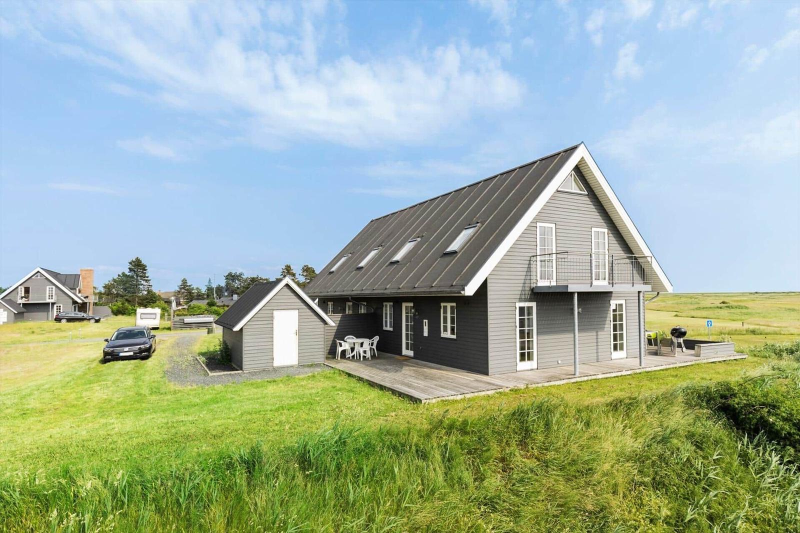 Moderne graue Hütte mit Terrasse und Garten. Dach mit Dachfenstern. Ferienhaus 407.