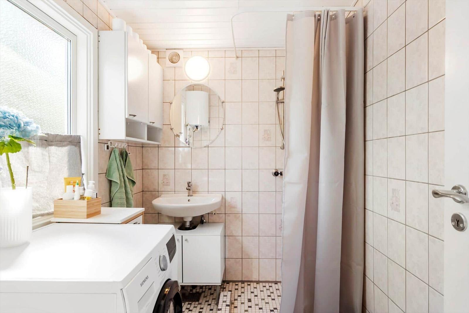 Schlafzimmer mit Bett, Nachttisch, Schrank und Fenster. Wände und Decke sind holzverkleidet.