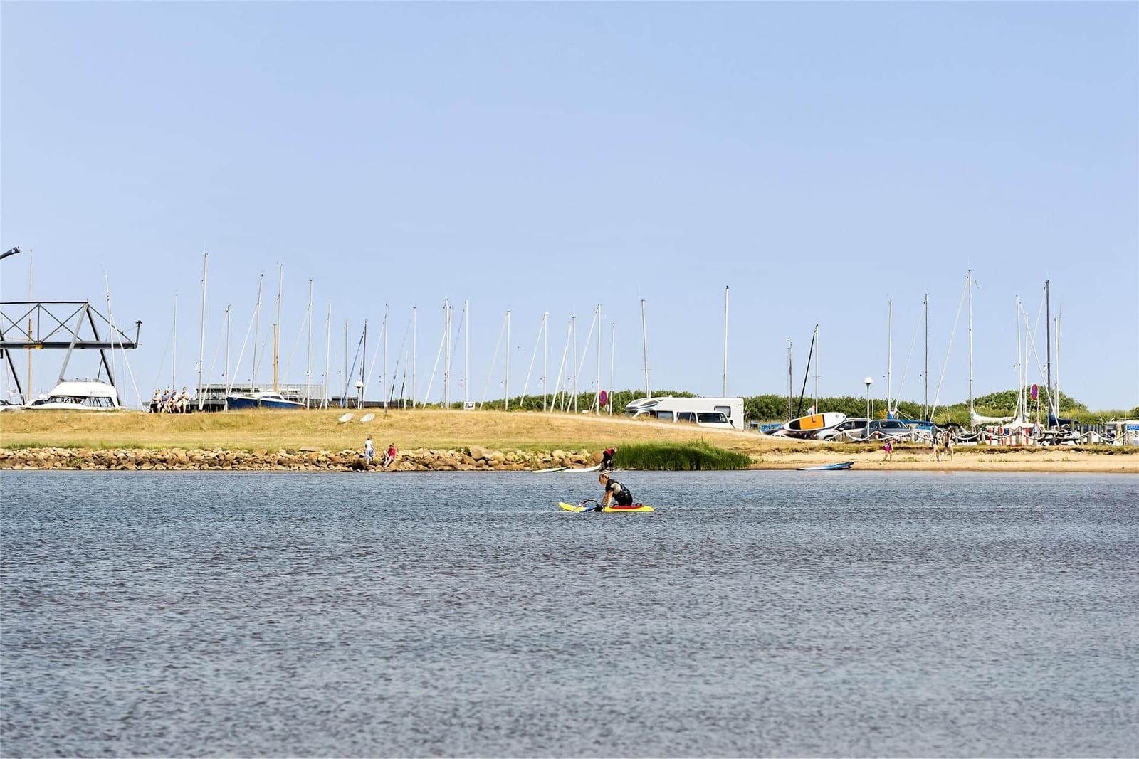 Hafen mit Booten und Stegen, rote Häuser im Hintergrund