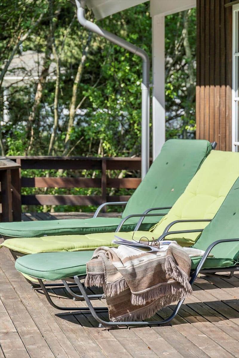 Terrasse mit Tisch, Stühlen und Blick in den Wald.