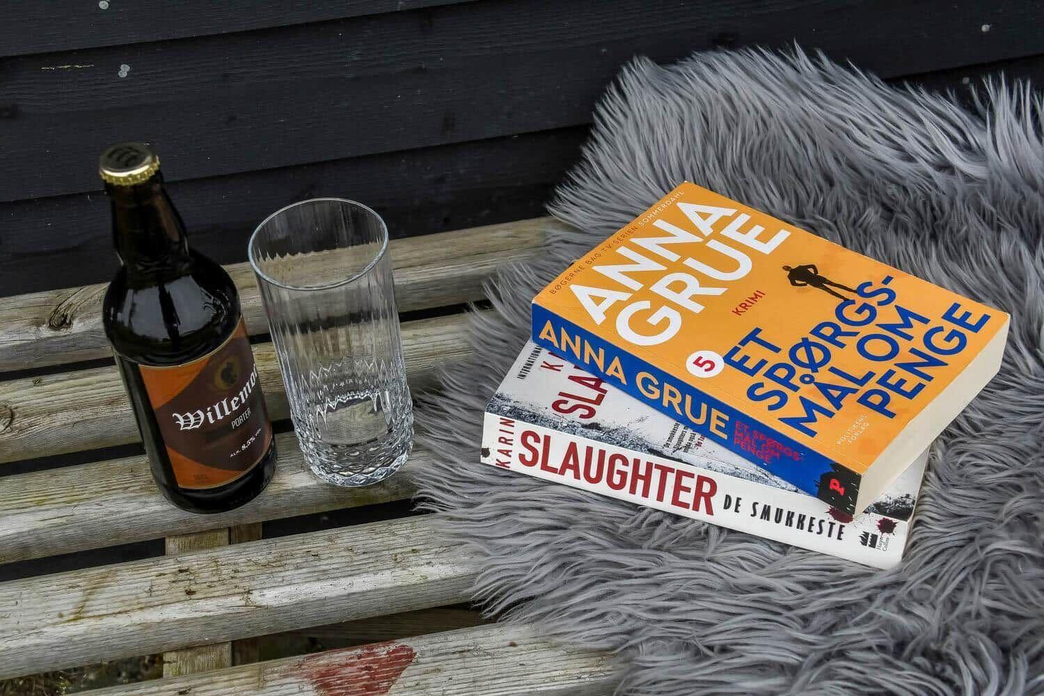 Außenbereich mit Grill, Tisch und Stühlen. Spielboxen auf dem Tisch. Holzterrasse und Pflanzen.