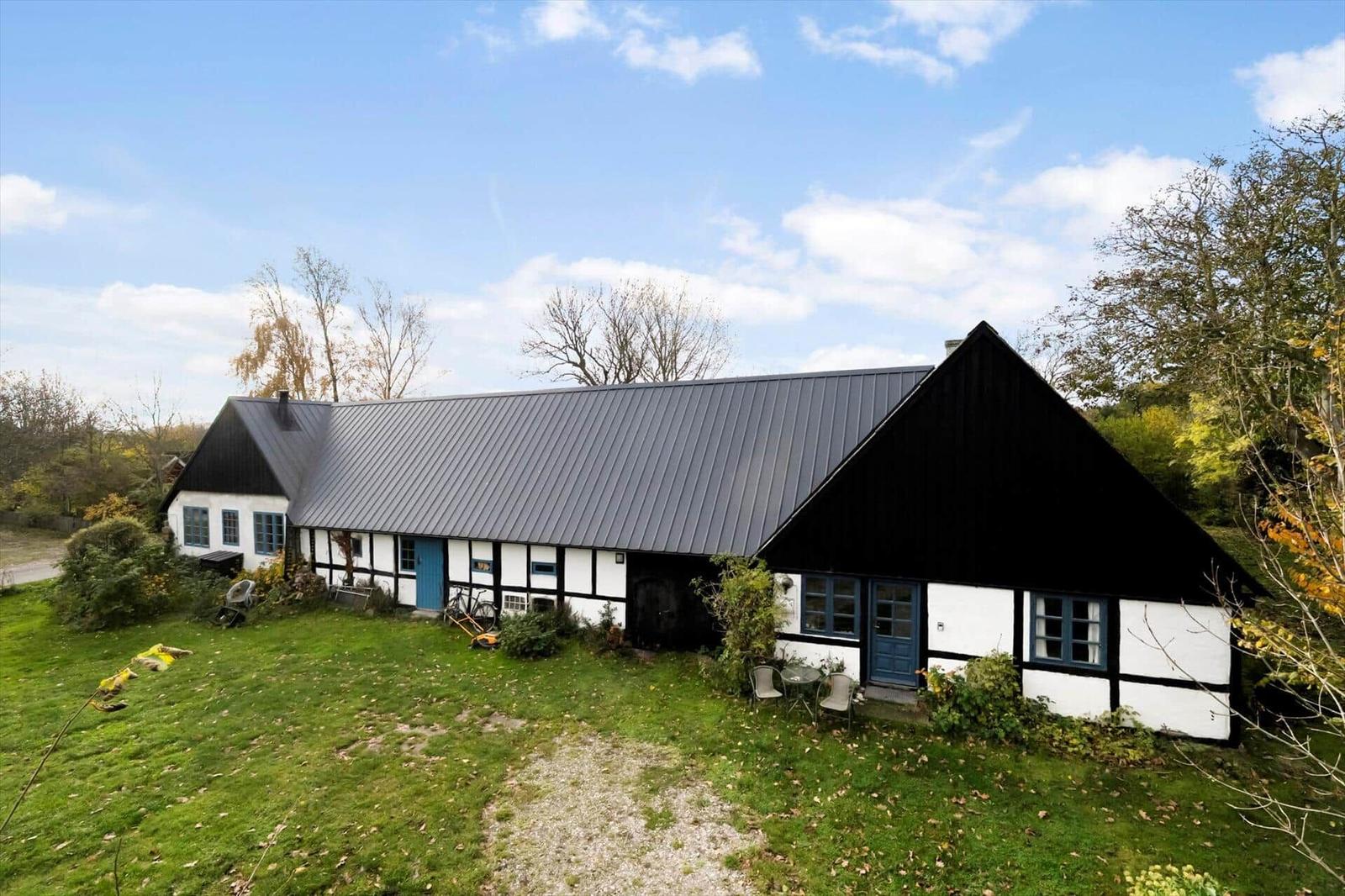 Haus mit Strohdach und gelber Tür am Wasser