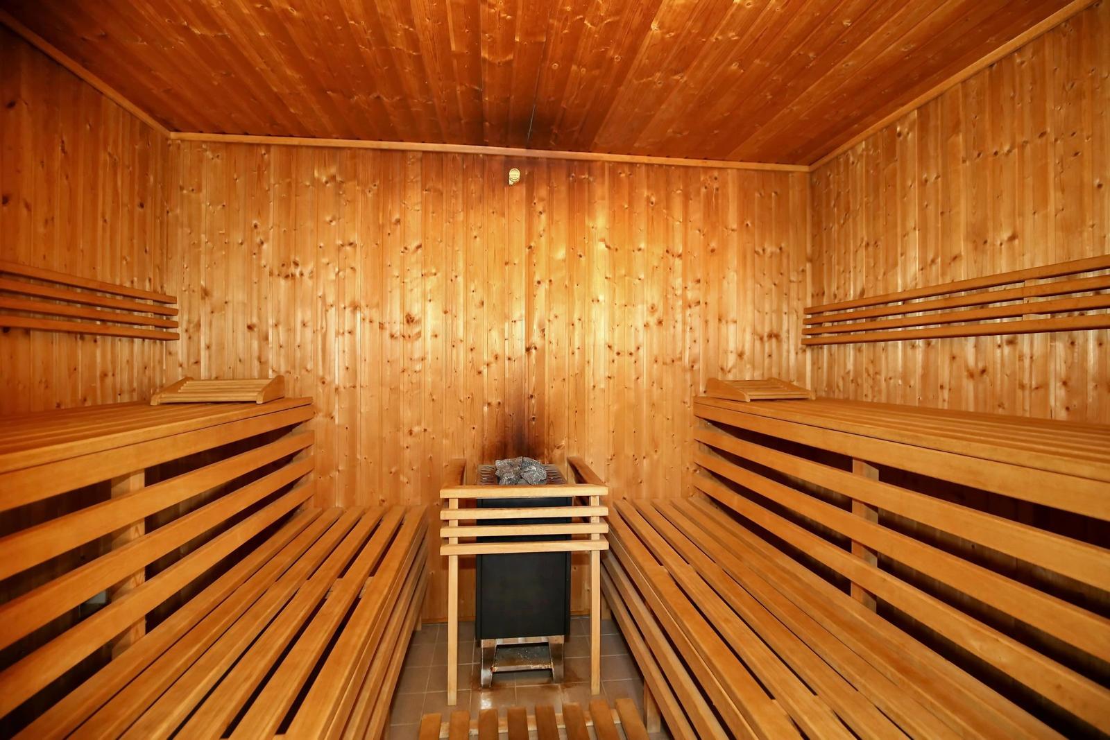 Pool mit Liegestühlen und Holztisch unter Bäumen