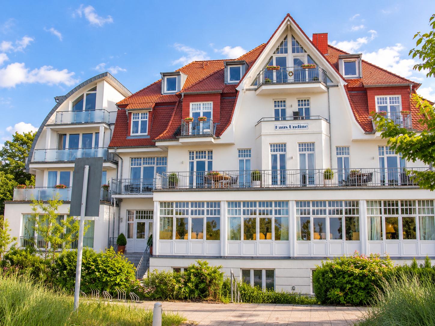 Wohnung mit zwei Schlafzimmern, Küche, Bad und Balkon mit Sonnenschirm.