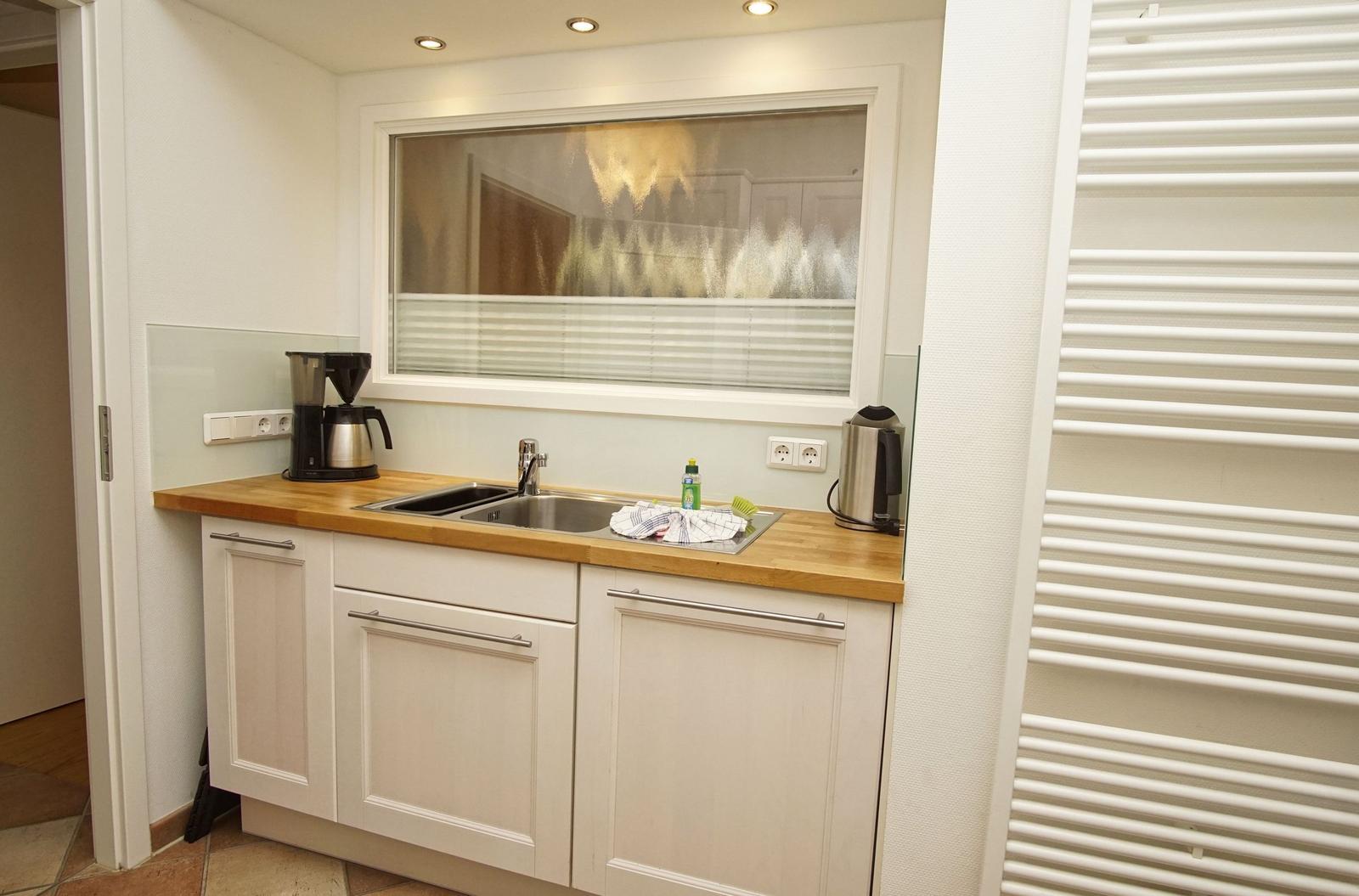 Badezimmer mit Badewanne, Dusche, Waschbecken und Toilette. Fenster mit Blick nach draußen.