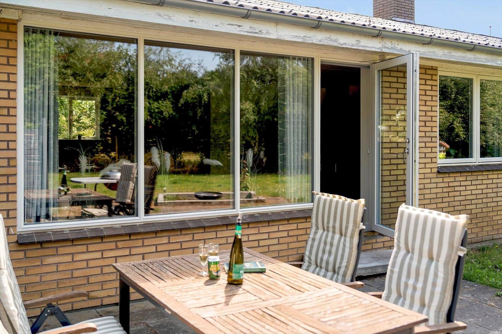 Esszimmer mit Holztisch, Lederstühlen und Wandbildern. Holzdecke und Boden.
