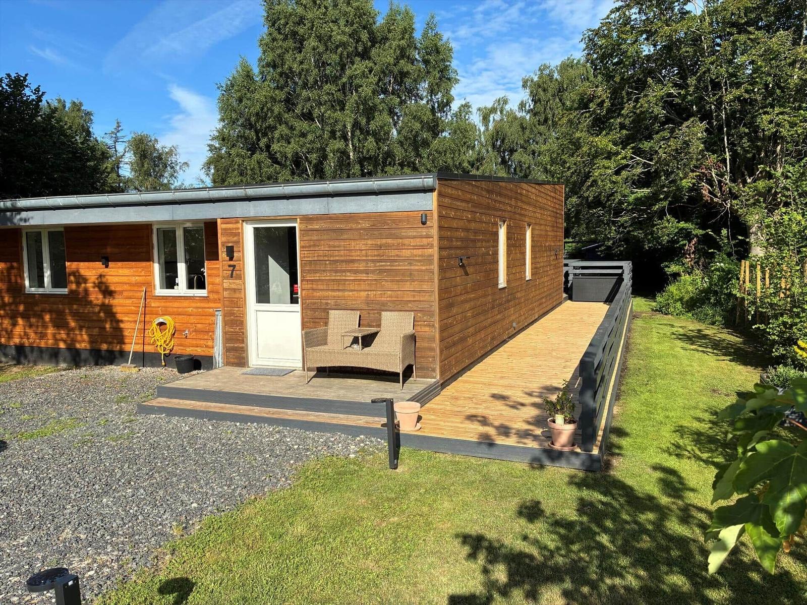 Essbereich mit Holztisch, Stühlen und Kartenwand. Küche im Hintergrund.