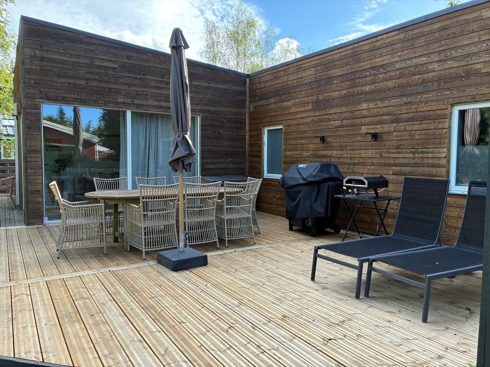 Küche mit Essbereich und Wohnzimmer. Holzboden, weiße Schränke, Esstisch mit Stühlen.