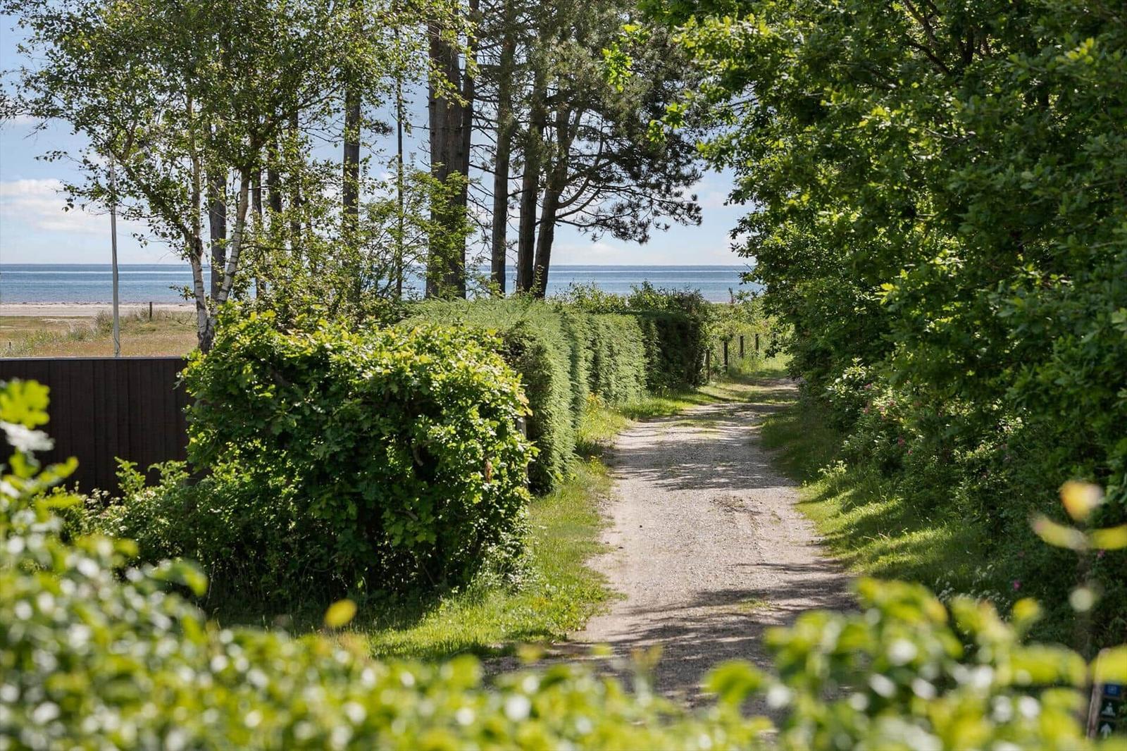 Küche und Essbereich mit Holzboden, weißen Wänden und Decke. Runder Tisch mit Stühlen und Fenster.