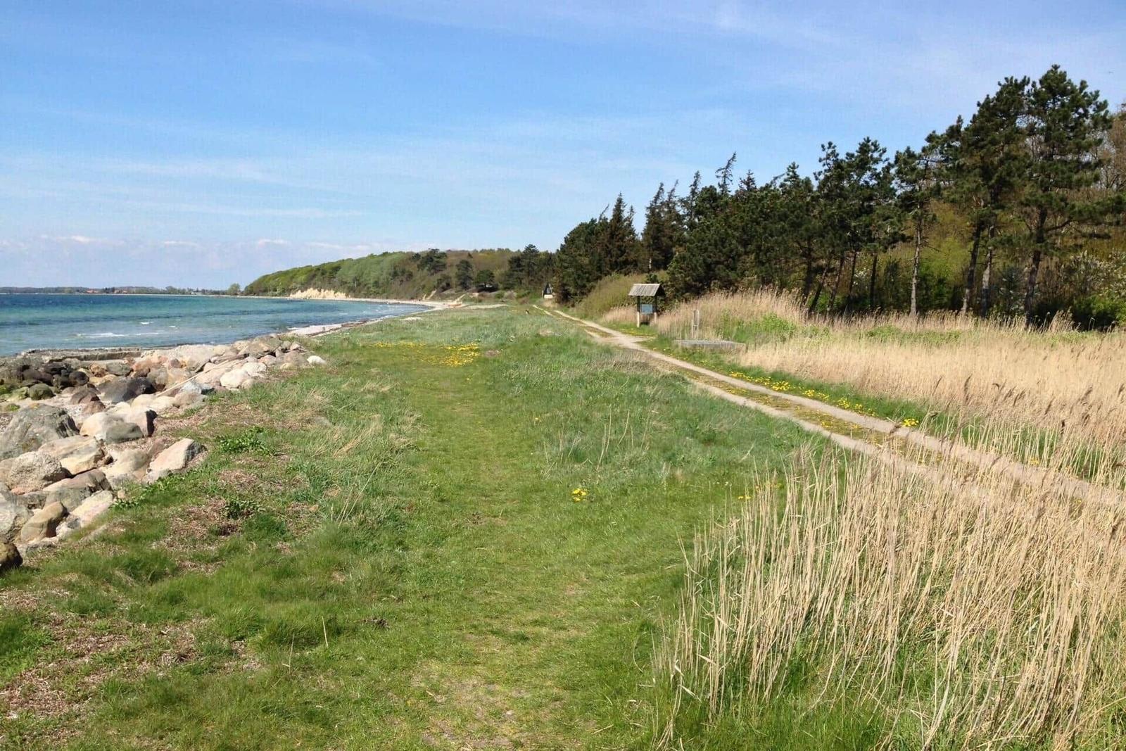 Strand mit Steinen und ruhigem Wasser. Ferienhaus direkt am Ufer.