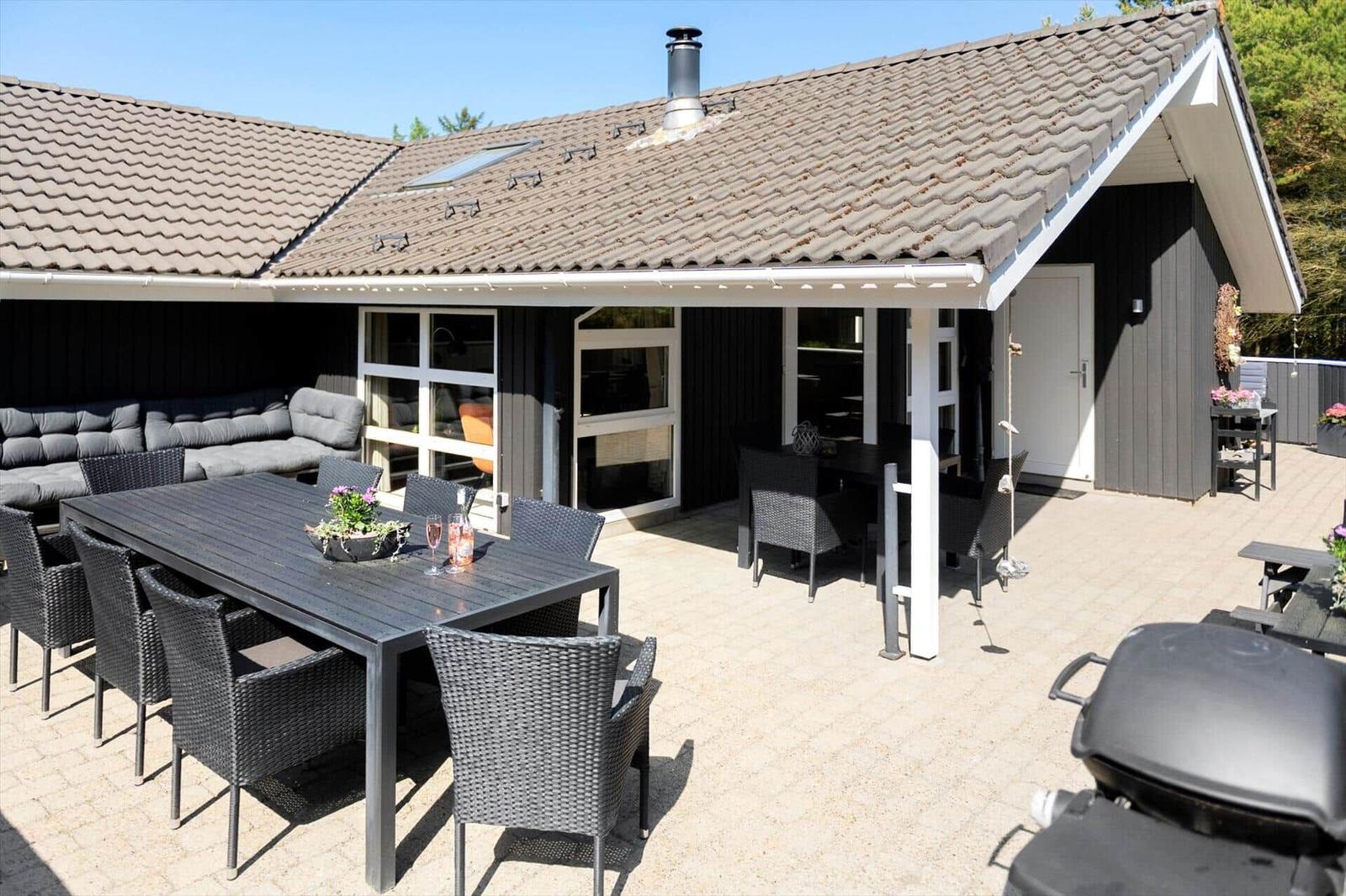 Haus mit großem Außenbereich, Grill und Sitzgruppe.