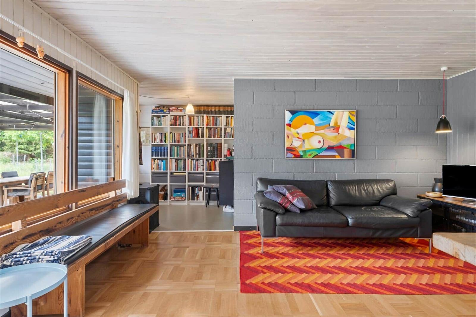 Ein Schlafzimmer mit Doppelstockbett, Bücherregal und Fenster mit Blick auf Grün.
