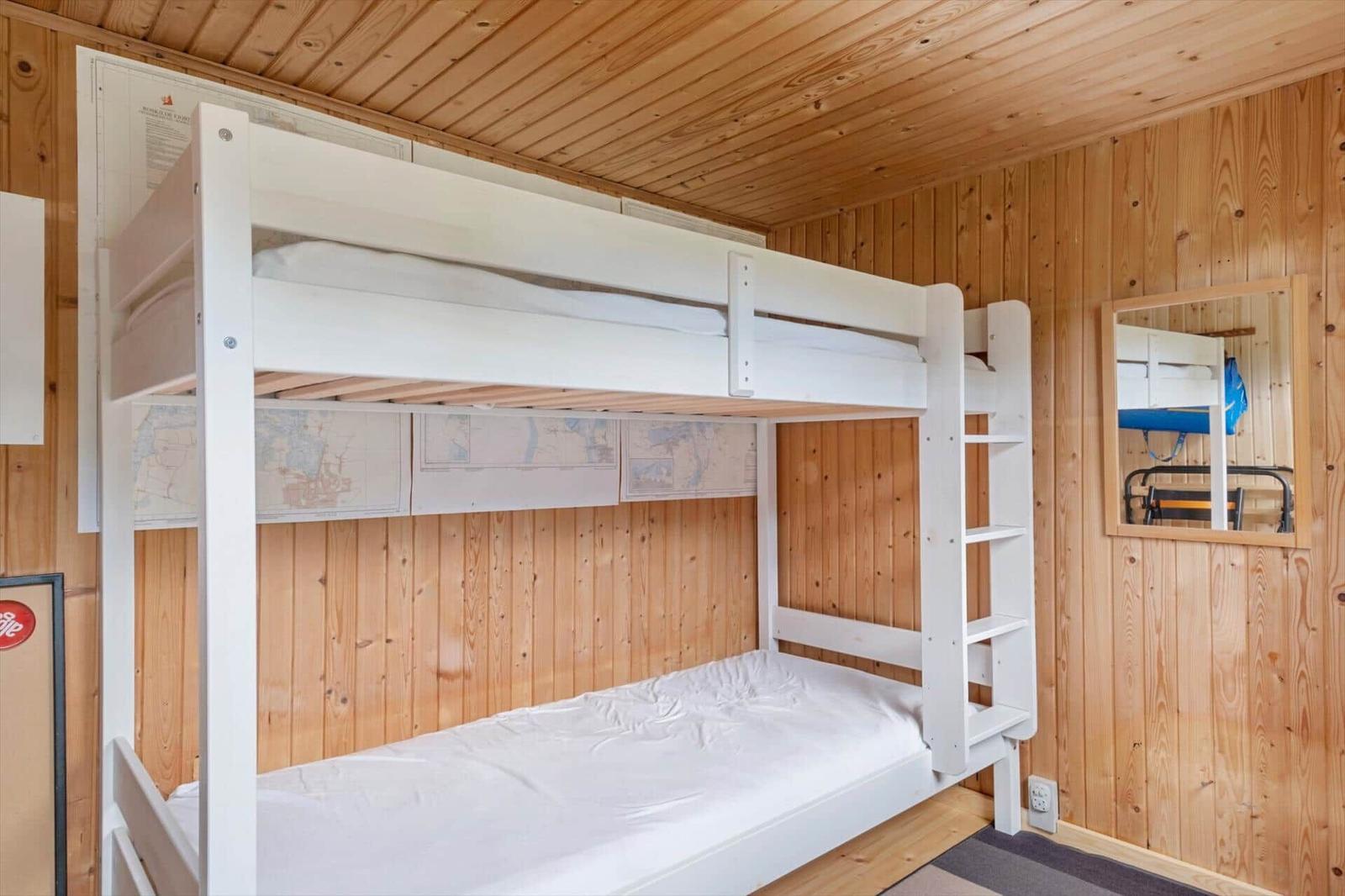 Holzstapel in integriertem Regal, Wand mit grünem Bild und Astdekoration.