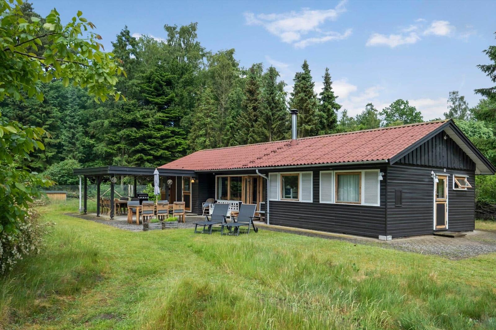 Wohnung mit Schlafzimmer, Küche und überdachter Terrasse. Raumübersicht mit Kompass.