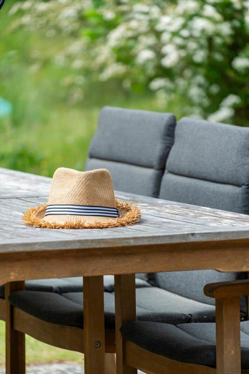 Haus mit Terrasse, Grillplatz und Trampolin im grünen Garten.