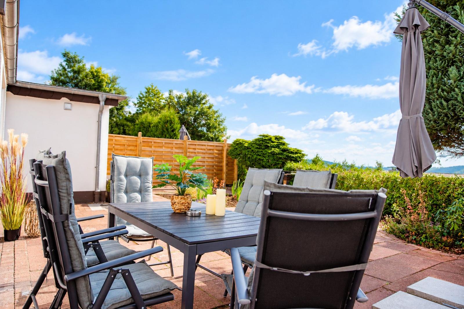 Wohnung mit Küche, Essbereich, Wohnzimmer, Schlafzimmer und Balkon mit Sitzgelegenheiten.