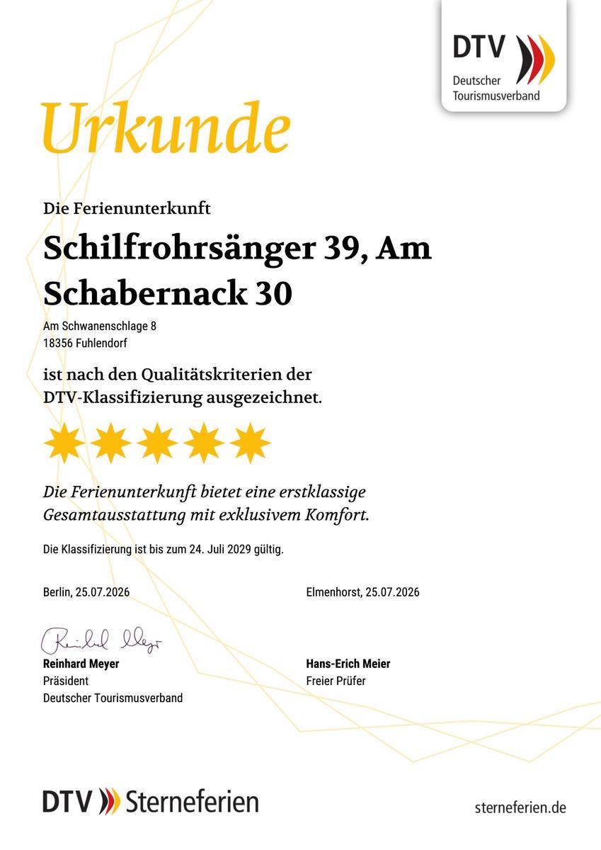 Menschen entspannen am Ufer eines Sees mit Booten im Hintergrund.