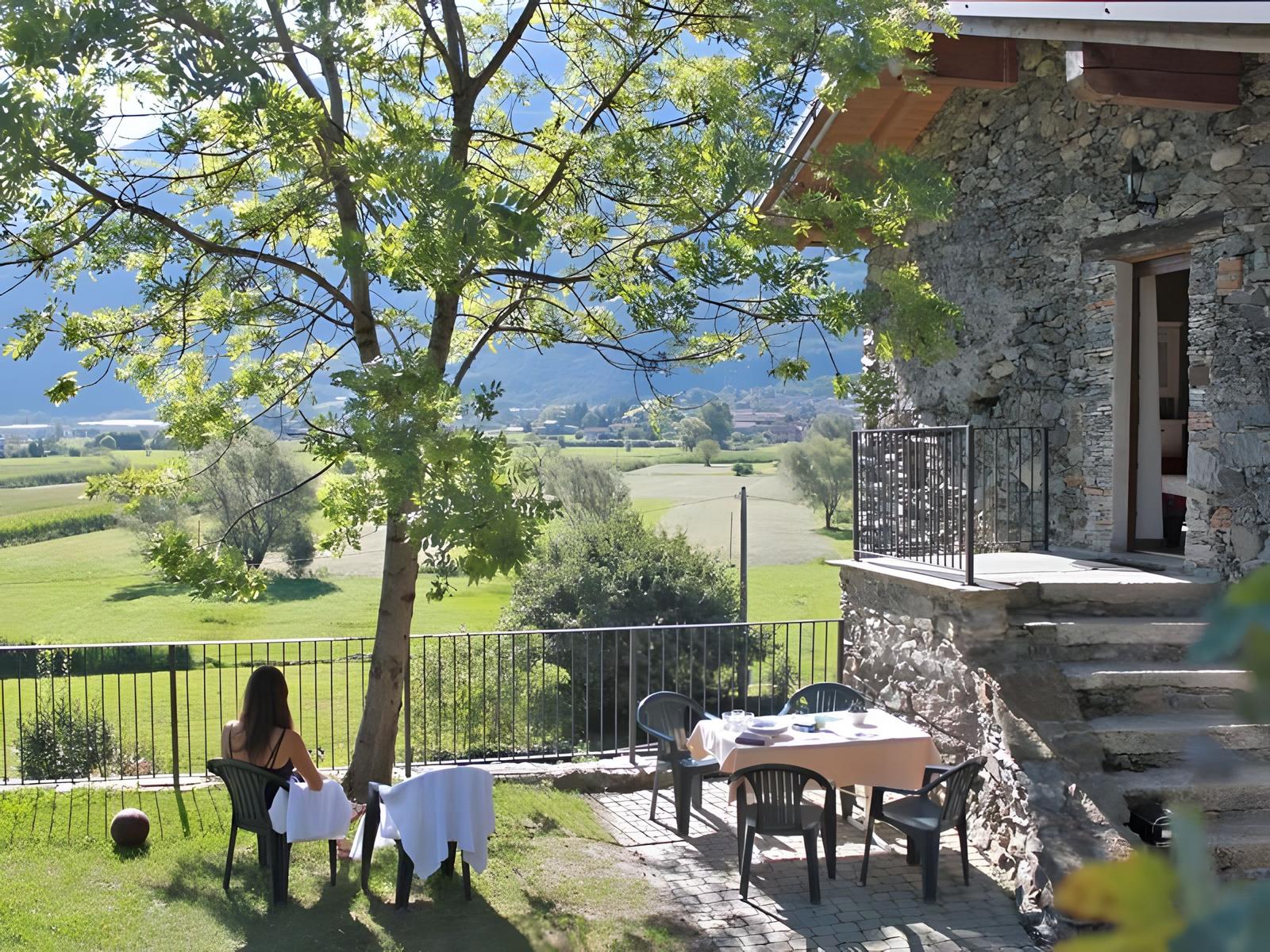 Poolbereich mit Liegestühlen und Blick auf Berge und Tal.