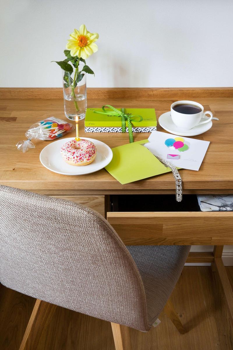 Doppelbett mit weißer Bettwäsche, zwei gelben Kissen und einer Zeitung.