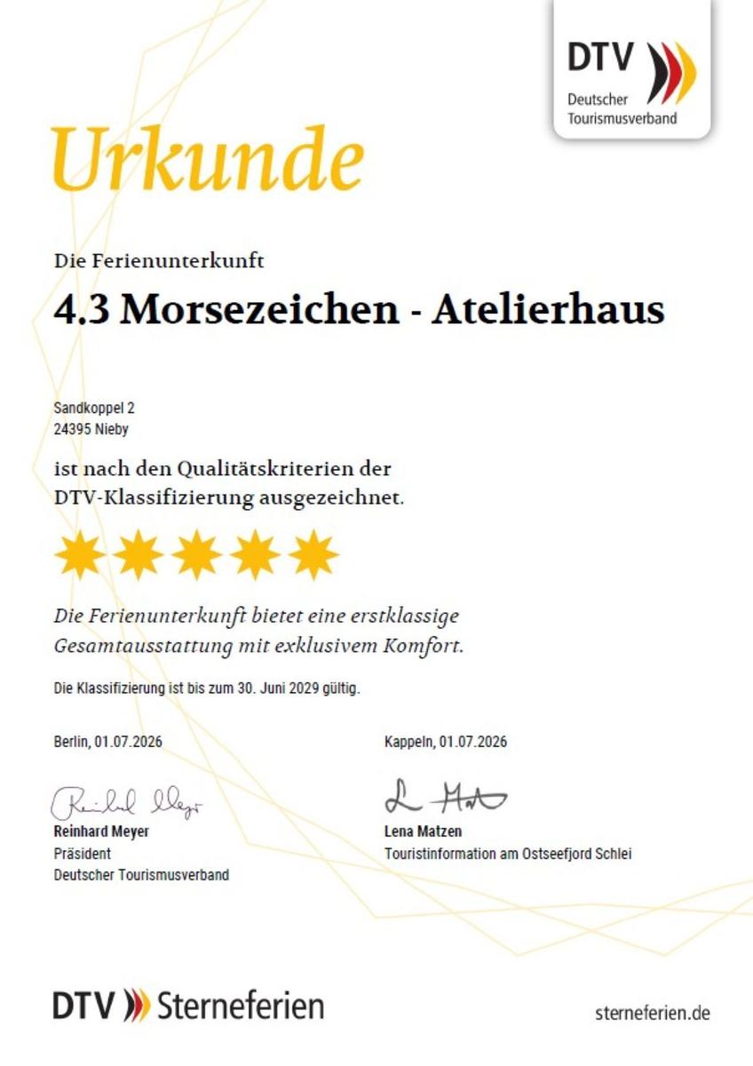Barrierefreie Dusche mit Duschbrause, Handlauf und Toilette mit Aufhängung.