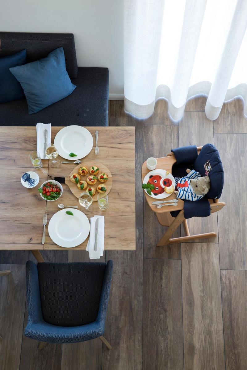 Sauna mit Holztür, Badewanne und Holzbank. Fenster mit Rollladen und Handtuch.