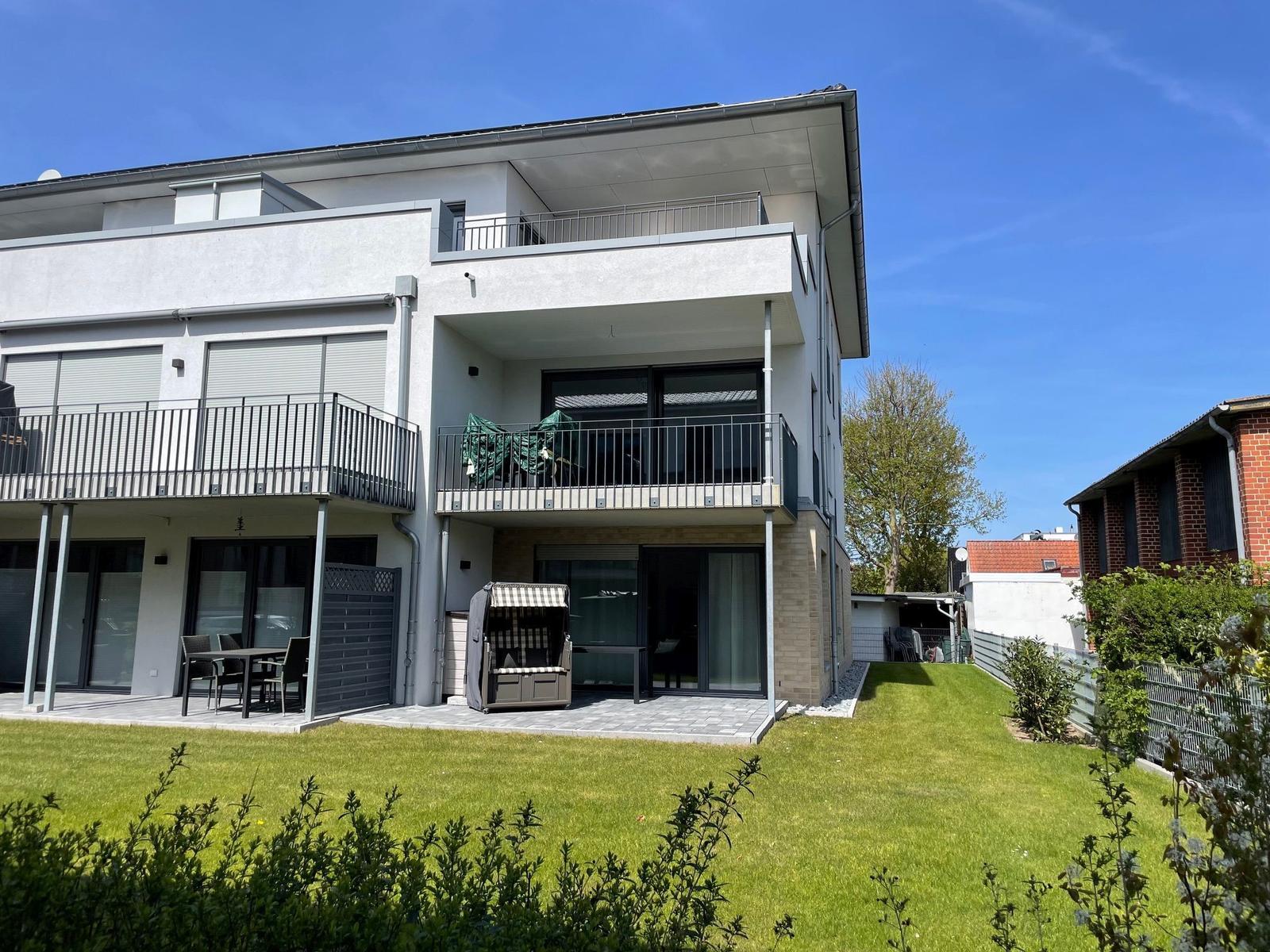 Terrasse mit Strandkorb und Tisch vor Glasfront
